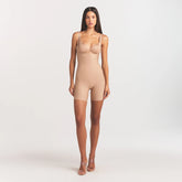 SKIMS BODY CORE SCULPT BACK SMOOTHING OPEN BUST MID THIGH BODYSUIT | CLAY ON A MODEL FRONT VIEW @