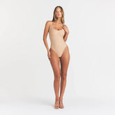 SKIMS BODY SCOOP LOW BACK THONG BODYSUIT | CLAY ON A MODEL FRONT VIEW @