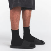 SKIMS ACCESSORIES MENS POOL SLIDE | ONYX ON A MODEL SIDE VIEW @ | FOCUS: 0.0, 1.0, 0.9