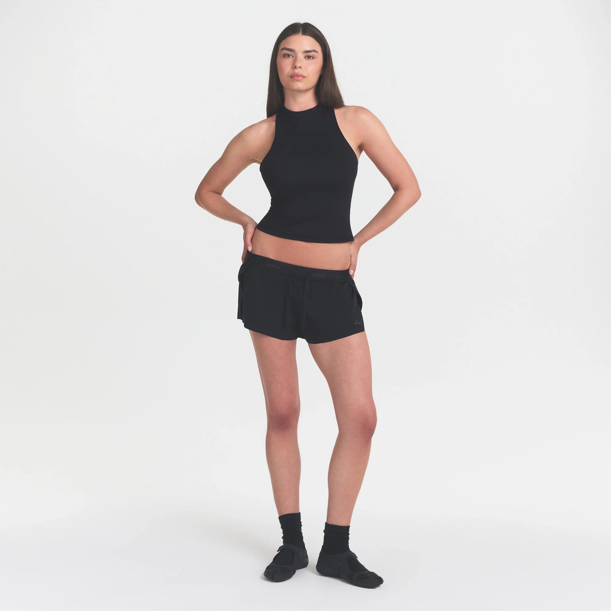 NikeSKIMS MATTE MOCK NECK RACER TANK | OBSIDIAN ON A MODEL FRONT VIEW @ | FOCUS: 0.9, 0.1, 0.7