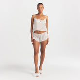 SKIMS ROMANCE CAMI AND SHORT SET | IVORY ON A MODEL FRONT VIEW @ | FOCUS: 0.0, 1.0, 0.9