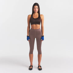 NikeSKIMS SATIN SHINE CAPRI 17" LEGGING | RESIN ON A MODEL FRONT VIEW