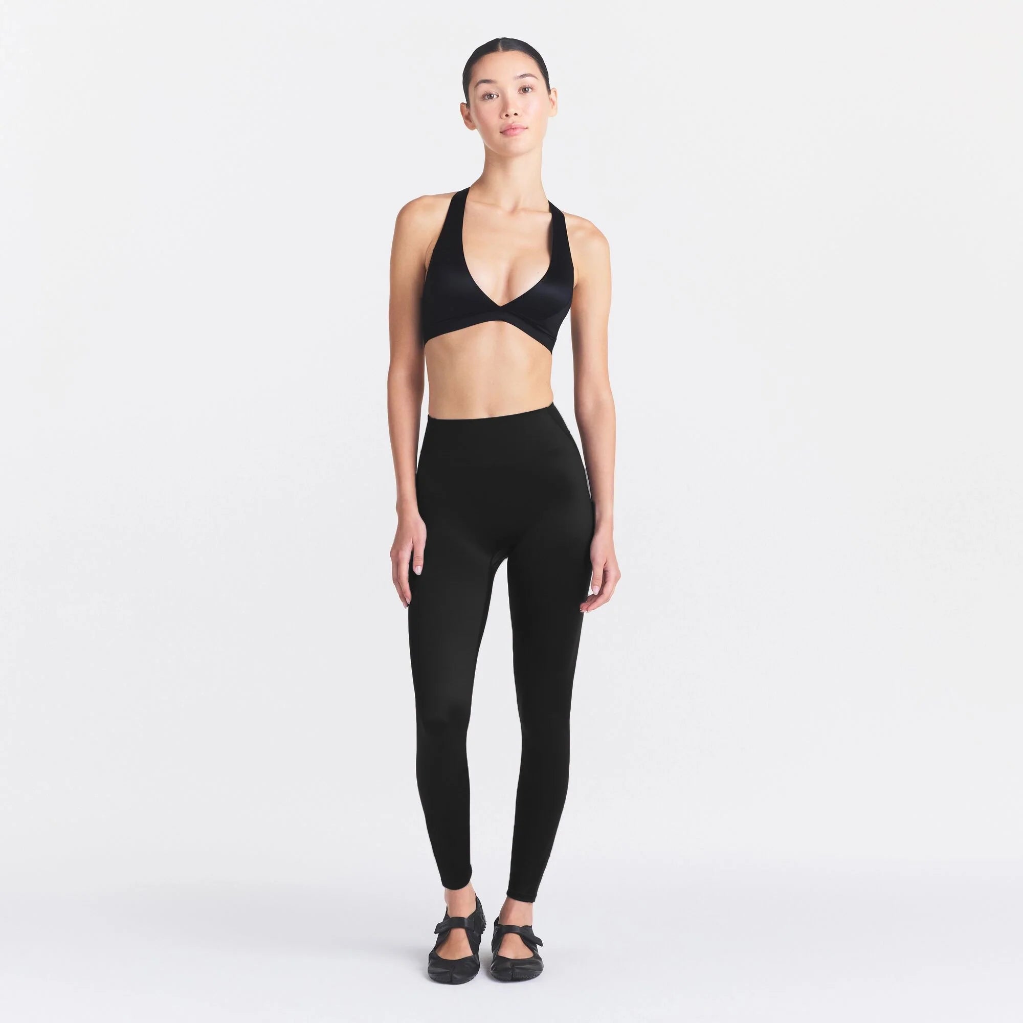 NikeSKIMS SATIN SHINE BONDED WAIST 26" LEGGING | OBSIDIAN ON A MODEL FRONT VIEW