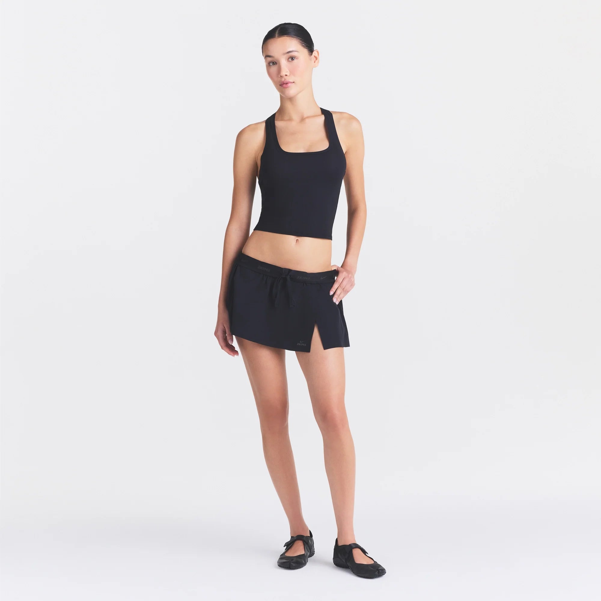 NikeSKIMS STRETCH NYLON SKORT | OBSIDIAN ON A MODEL FRONT VIEW @ | FOCUS: 0.0, 1.0, 0.9