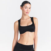 NikeSKIMS SATIN SHINE WIDE SCOOP BRA | OBSIDIAN ON A MODEL SIDE VIEW @ | FOCUS: 0.0, 1.0, 0.9