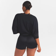 NikeSKIMS STRETCH KNIT OVERSIZED V-NECK TOP | OBSIDIAN ON A MODEL SIDE VIEW @ | FOCUS: 0.0, 1.0, 0.9