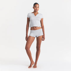 SKIMS SLEEP HENLEY AND FOLDOVER SHORT SET | LIGHT HEATHER GREY ON A MODEL FRONT VIEW @ | FOCUS: 0.0, 1.0, 0.9