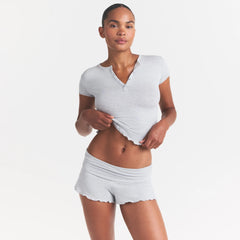 SKIMS SLEEP HENLEY AND FOLDOVER SHORT SET | LIGHT HEATHER GREY ON A MODEL SIDE VIEW @ | FOCUS: 0.0, 1.0, 0.9