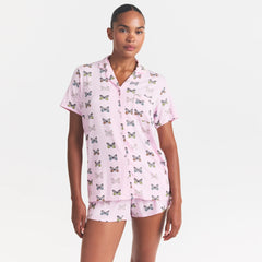 SKIMS SLEEP SHORT SLEEVE BUTTON UP SET | PEONY BUTTERFLY PRINT ON A MODEL SIDE VIEW @ | FOCUS: 0.0, 1.0, 0.9