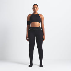 NikeSKIMS MATTE FOOTSIE GRIP LEGGING | OBSIDIAN ON A MODEL FRONT VIEW @ | FOCUS: 0.9, 0.1, 0.7