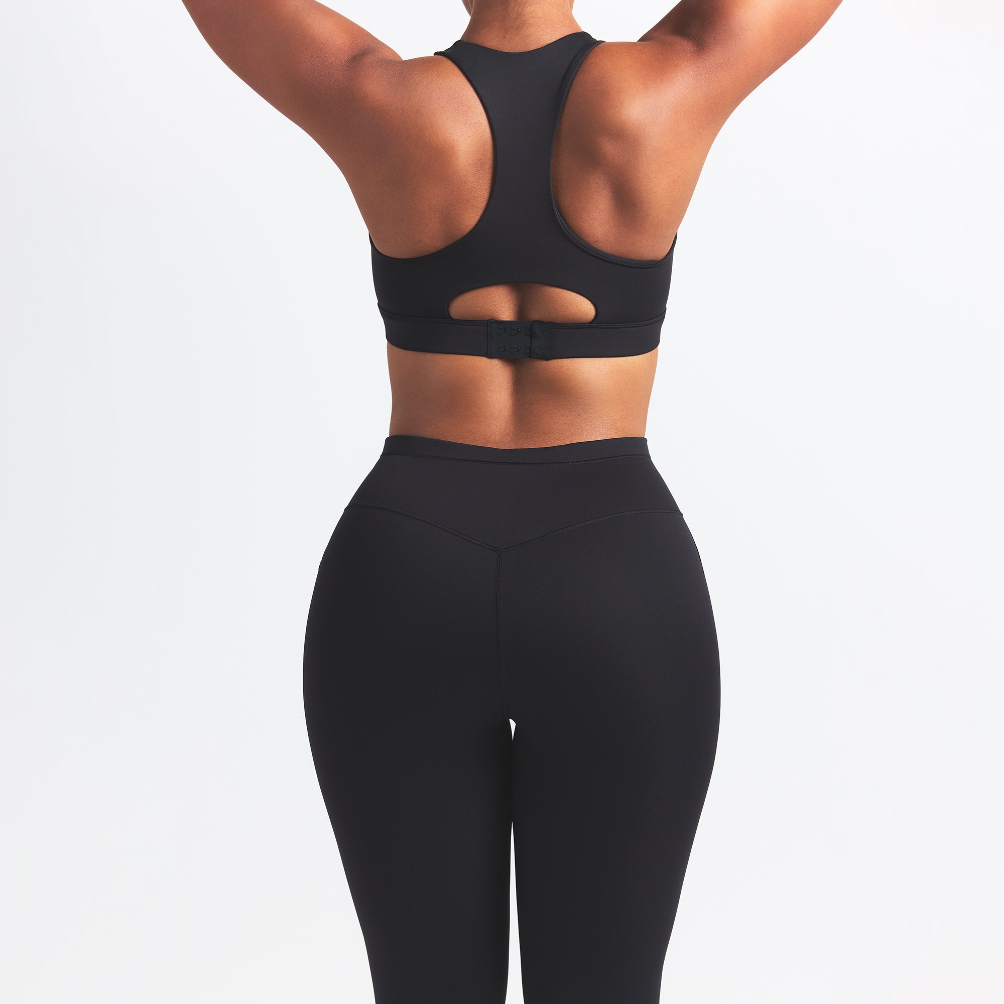 NikeSKIMS MATTE FOOTSIE GRIP LEGGING | OBSIDIAN ON A MODEL BACK VIEW