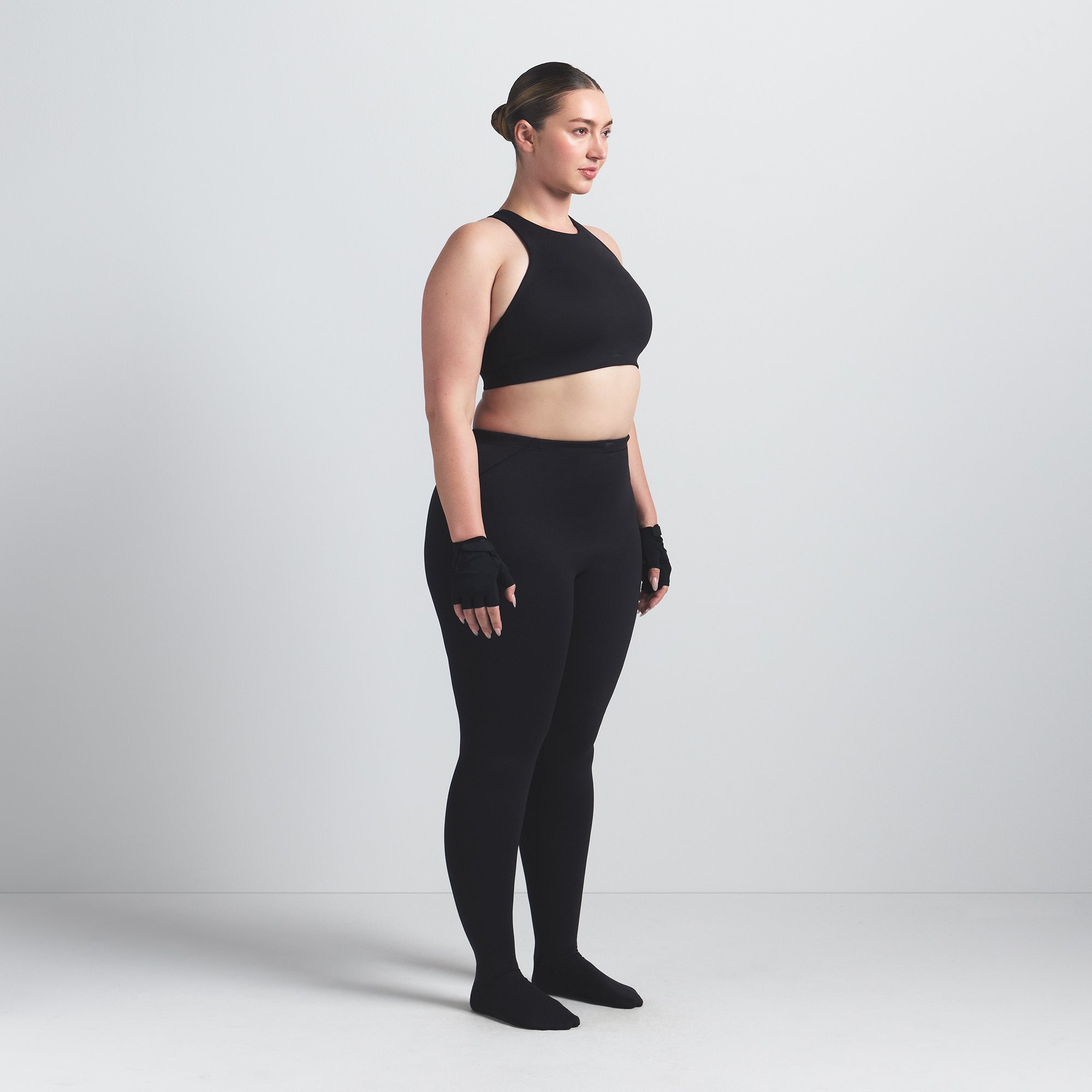 NikeSKIMS MATTE FOOTSIE GRIP LEGGING | OBSIDIAN ON A MODEL SIDE VIEW