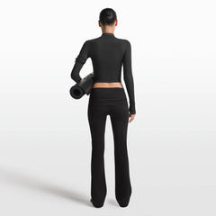 NikeSKIMS MATTE FOLDOVER SLIM FLARE LEGGING | OBSIDIAN ON A MODEL FRONT VIEW @ | FOCUS: 0.0, 1.0, 0.9