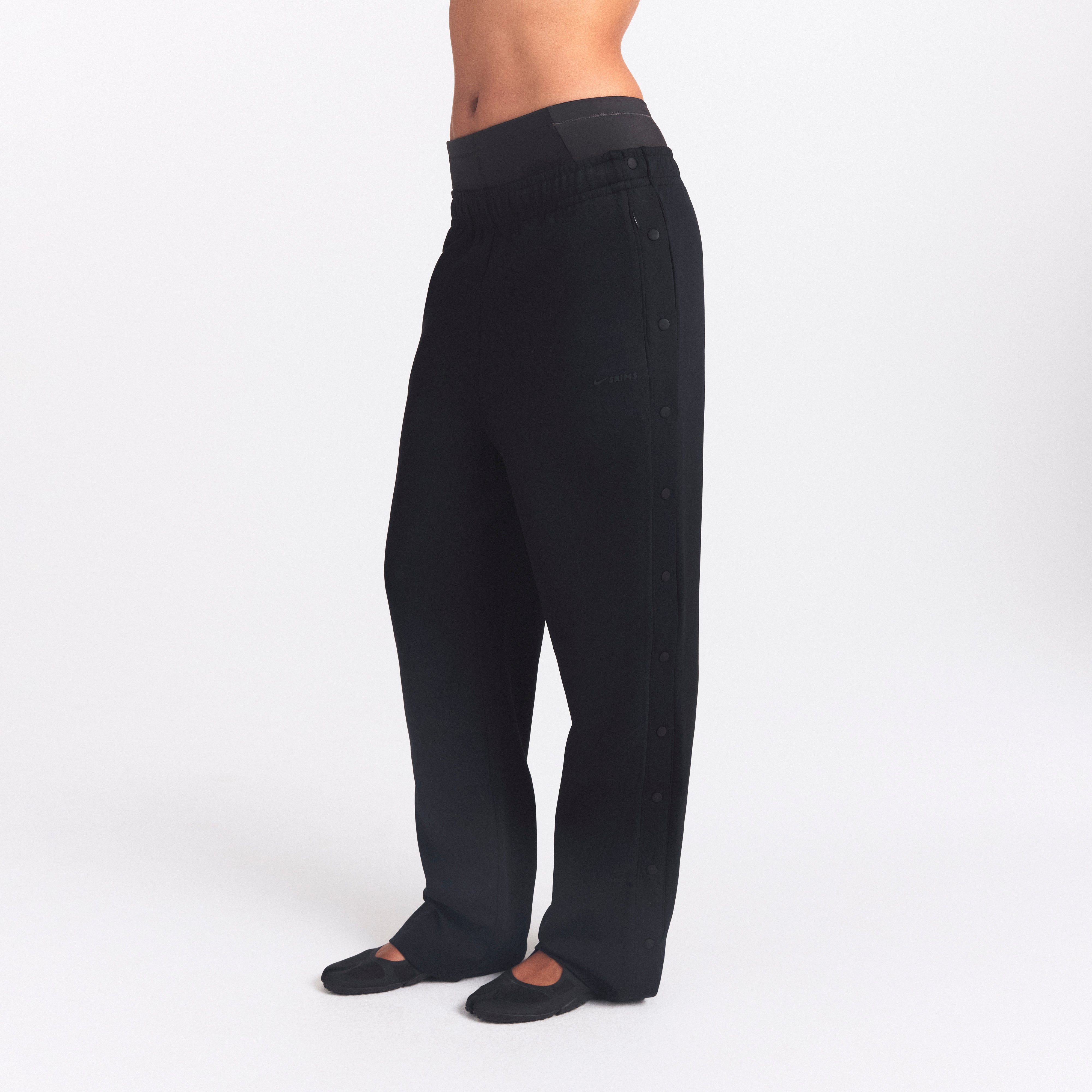 NikeSKIMS MATTE TRICOT SIDE SNAPS PANT | OBSIDIAN ON A MODEL SIDE VIEW @ | FOCUS: 0.0, 1.0, 0.9