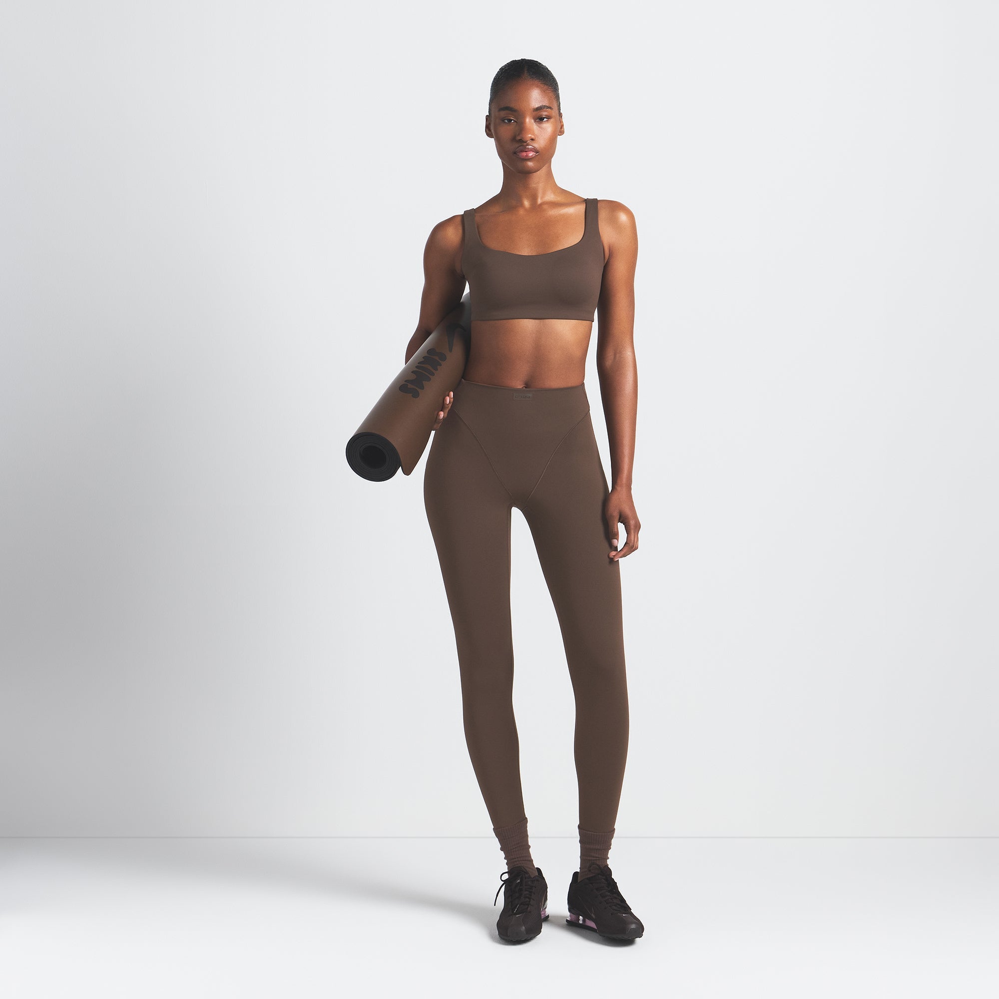 NikeSKIMS MATTE SCOOP NECK BRA | DARK SEPIA ON A MODEL FRONT VIEW @ | FOCUS: 0.9, 0.1, 0.7