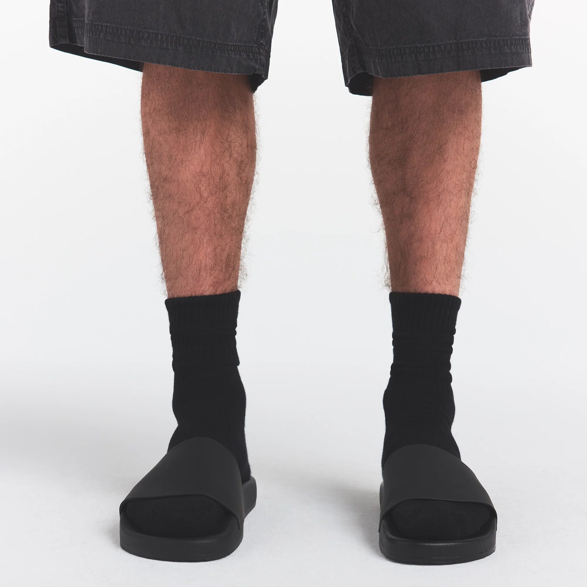 SKIMS ACCESSORIES MENS POOL SLIDE | ONYX ON A MODEL FRONT VIEW @ | FOCUS: 0.0, 1.0, 0.9