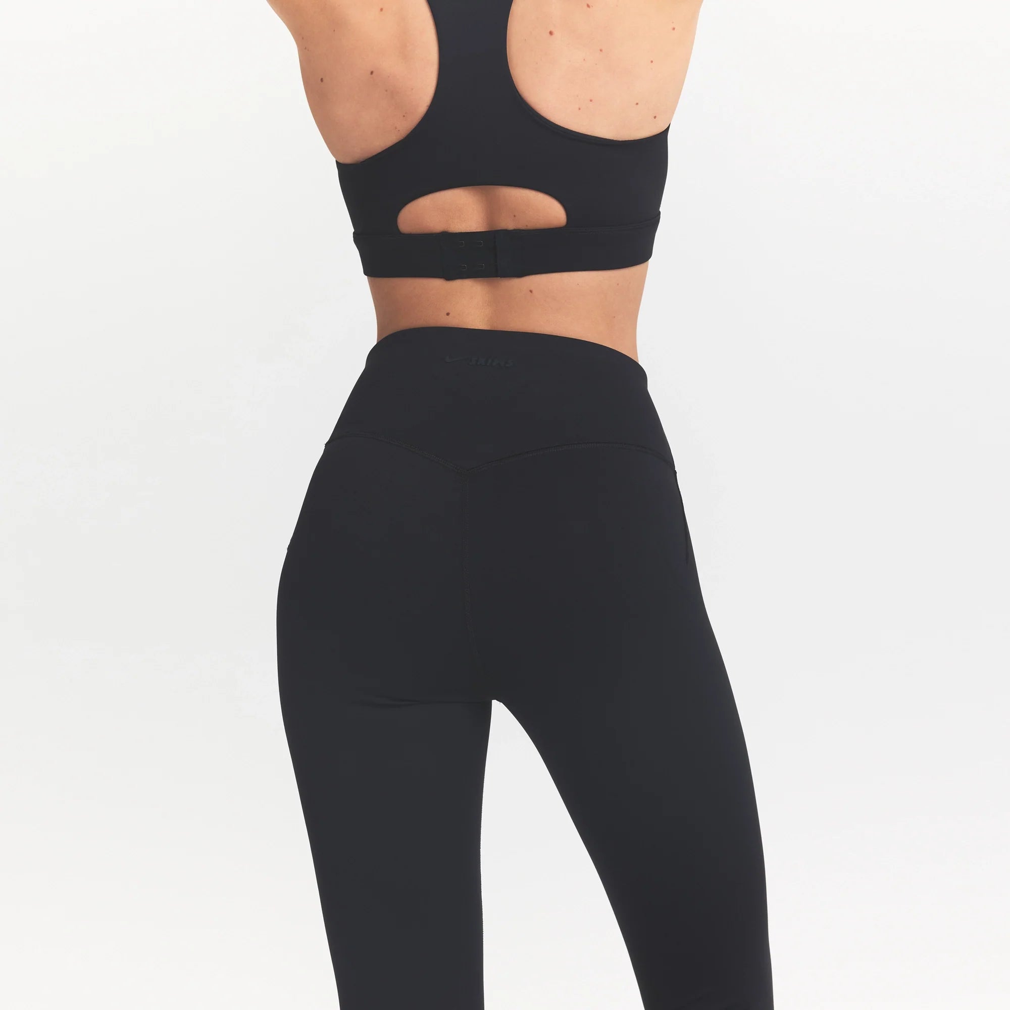 NikeSKIMS MATTE CROP 17" LEGGING | OBSIDIAN ON A MODEL BACK VIEW @ | FOCUS: 0.0, 1.0, 0.9