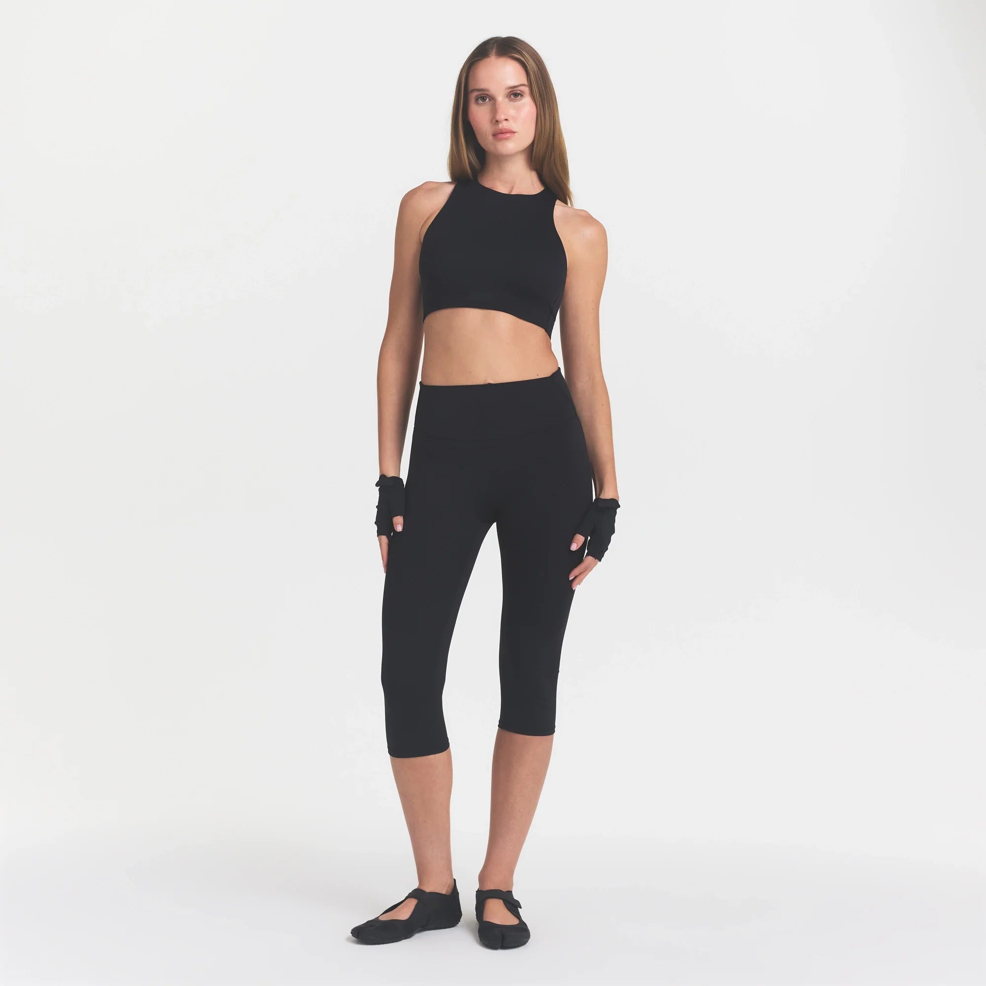 NikeSKIMS MATTE CROP 17" LEGGING | OBSIDIAN ON A MODEL FRONT VIEW @ | FOCUS: 0.0, 1.0, 0.9