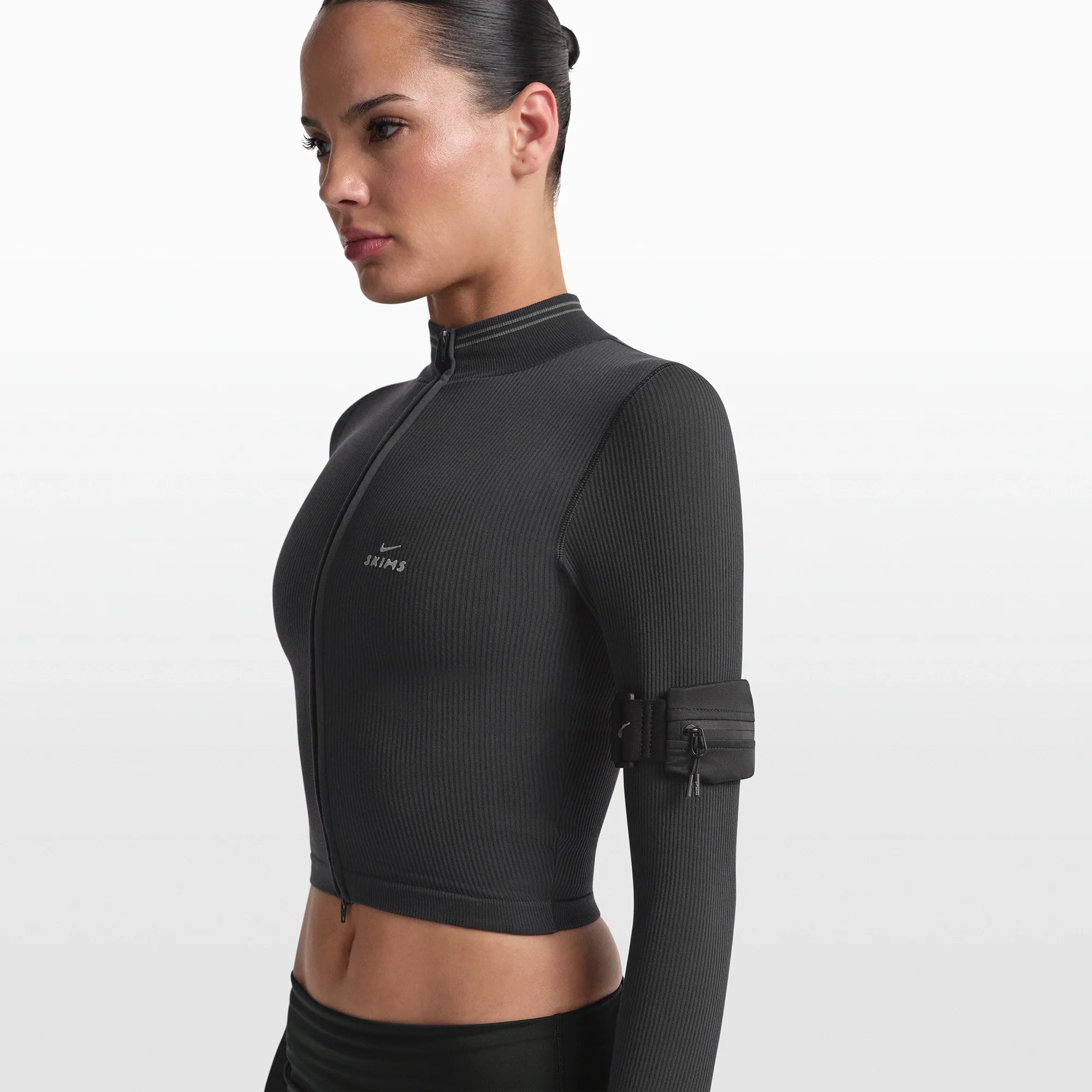 NikeSKIMS ACCESSORIES ARMBAND | OBSIDIAN ON A MODEL FRONT VIEW @ | FOCUS: 0.0, 1.0, 0.9