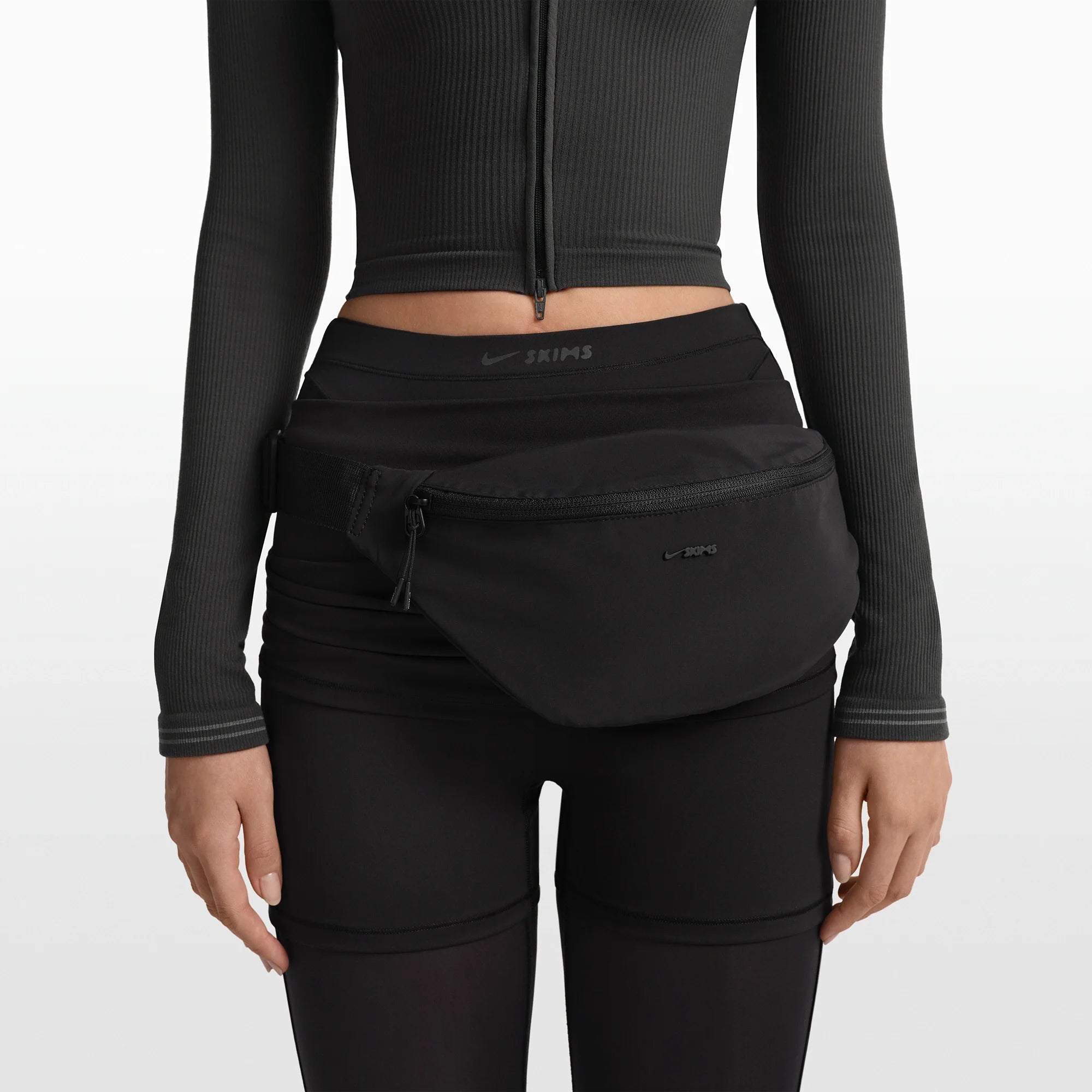 NikeSKIMS ACCESSORIES FANNY PACK | OBSIDIAN ON A MODEL FRONT VIEW @ | FOCUS: 0.0, 1.0, 0.9
