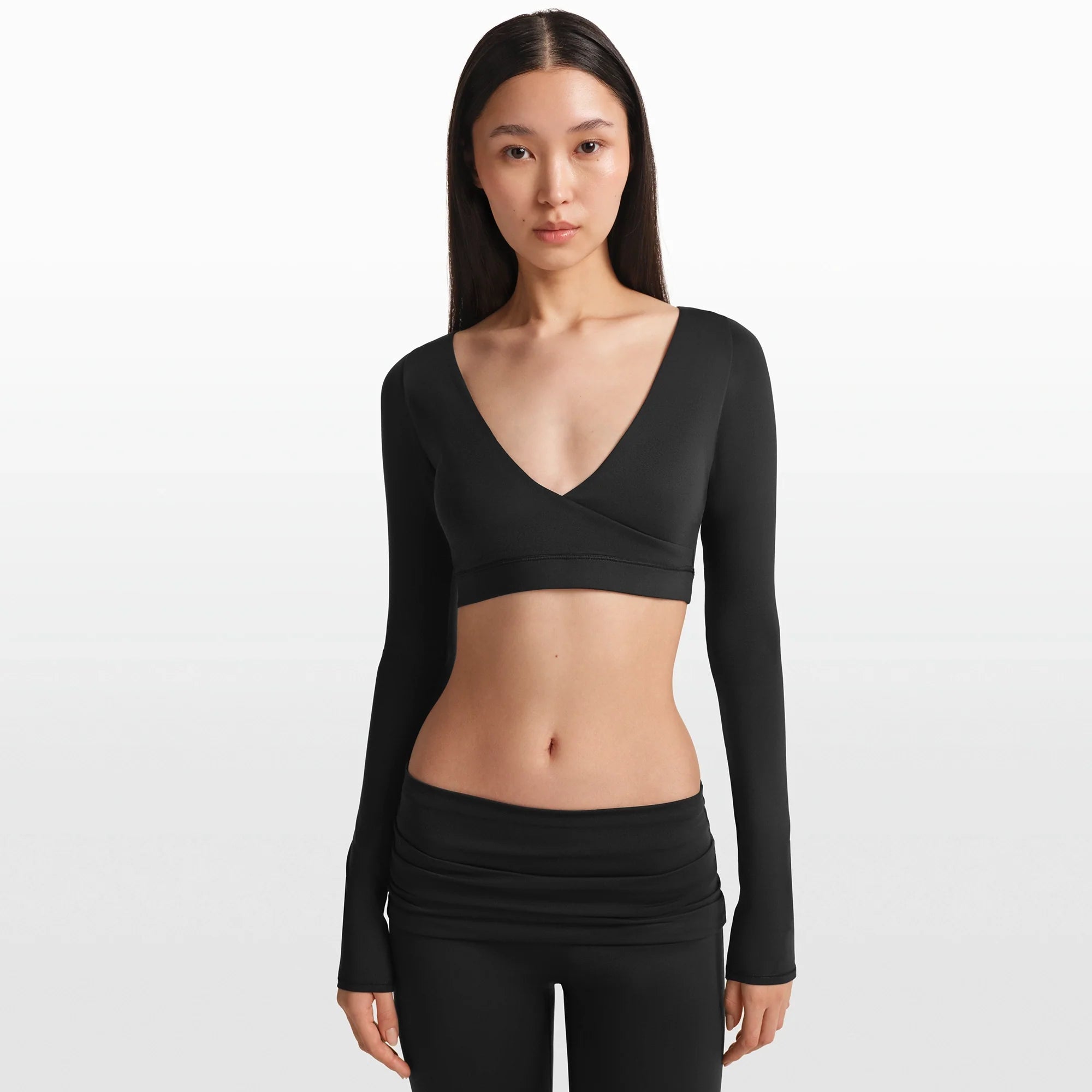 NikeSKIMS MATTE WRAP LONG SLEEVE CROPPED TOP | OBSIDIAN ON A MODEL FRONT VIEW @ | FOCUS: 0.0, 1.0, 0.9