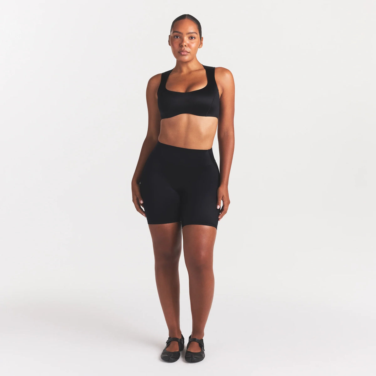 NikeSKIMS SATIN SHINE BONDED WAIST 7" BIKER SHORT | OBSIDIAN ON A MODEL FRONT VIEW