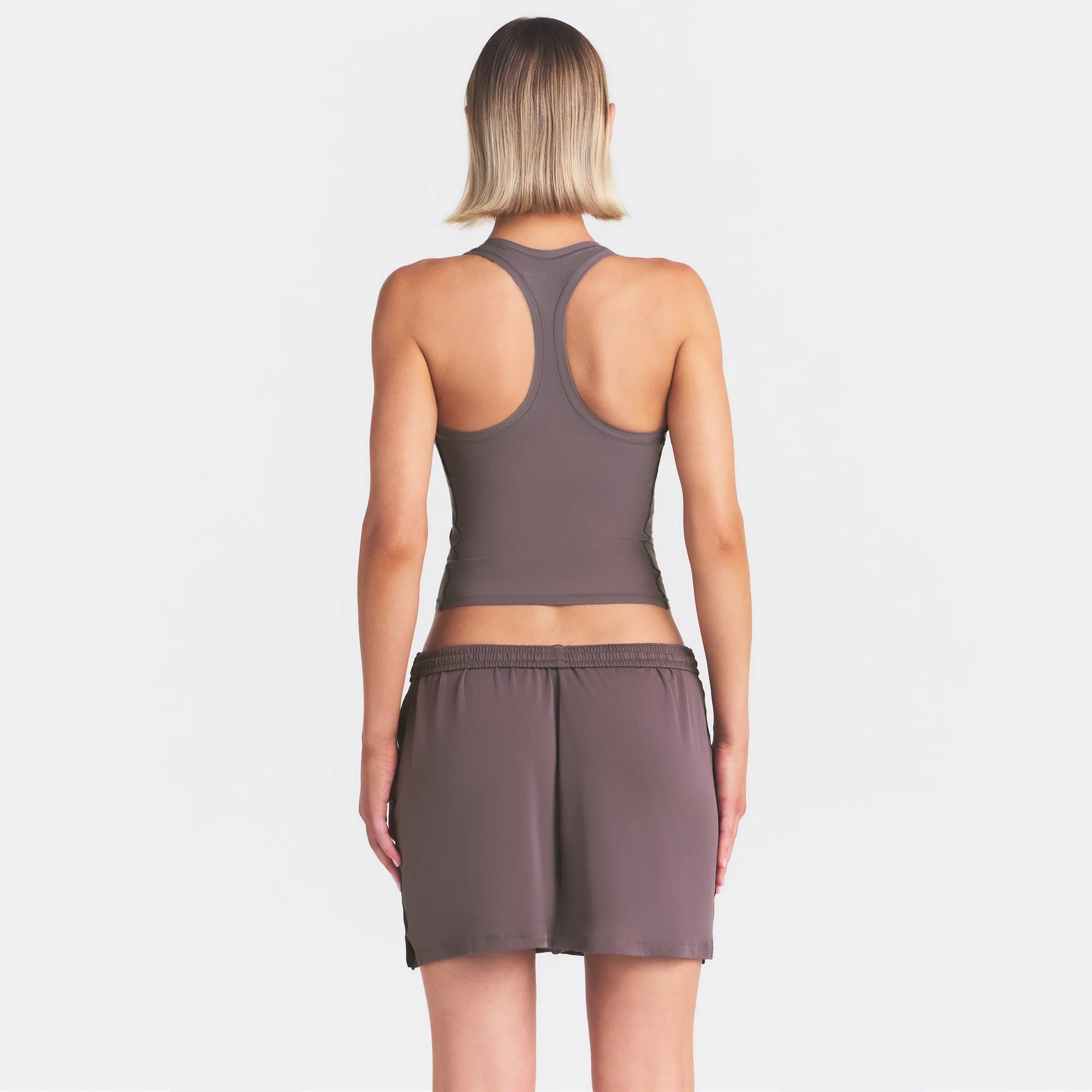 NikeSKIMS STRETCH KNIT DOLPHIN SHORT | RESIN ON A MODEL SIDE VIEW @ | FOCUS: 0.0, 1.0, 0.9