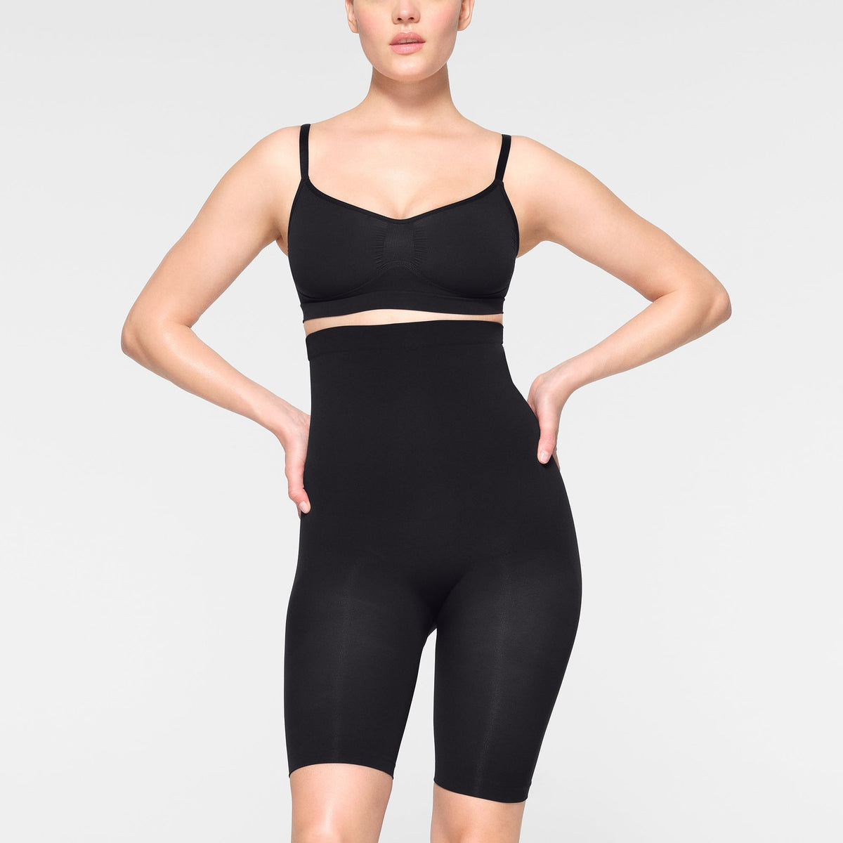SEAMLESS SCULPT HIGH-WAISTED ABOVE THE KNEE SHORT WORN BY A MODEL IN FRONT VIEW
