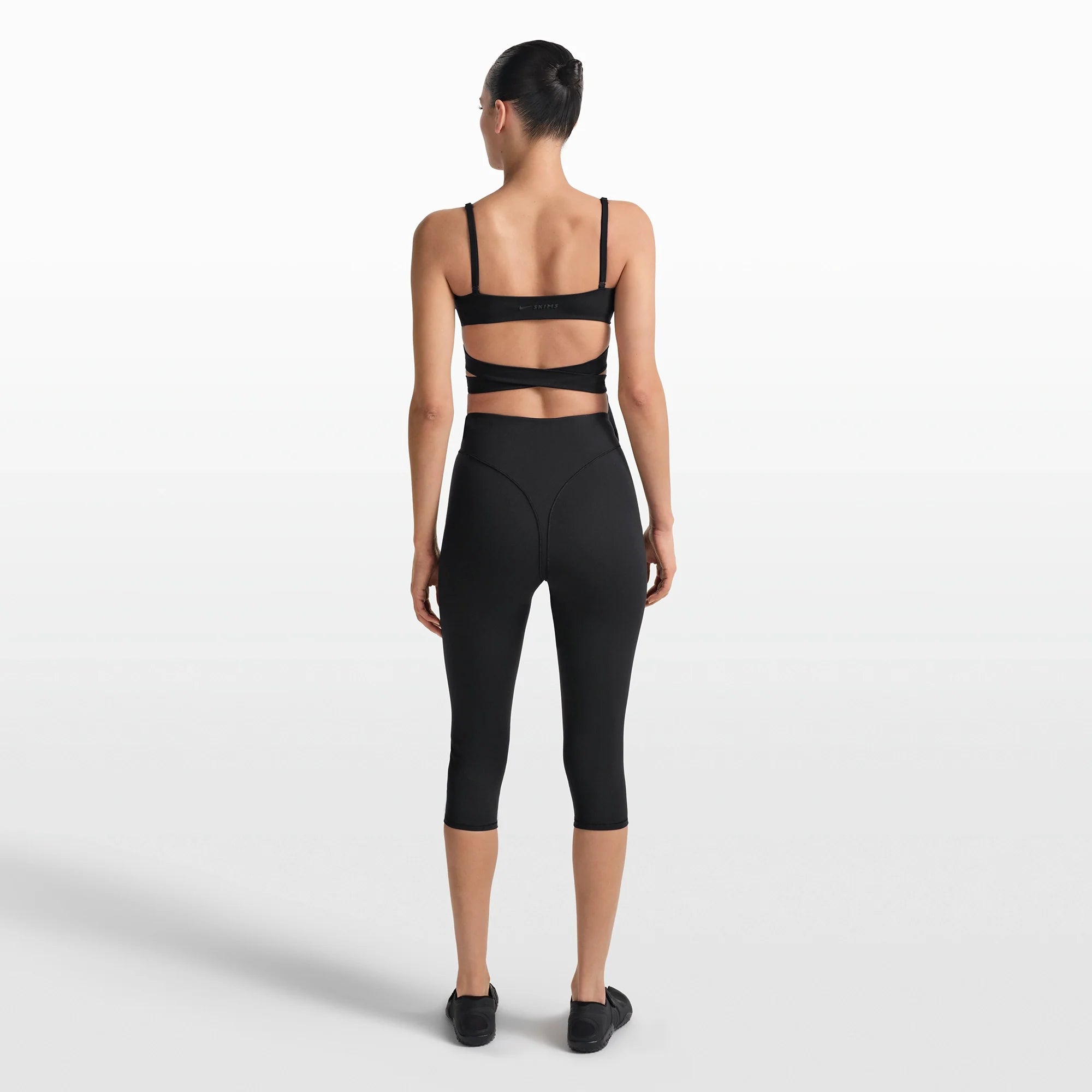 NikeSKIMS MATTE WRAP FRONT BRA | OBSIDIAN ON A MODEL FRONT VIEW @ | FOCUS: 0.0, 1.0, 0.9